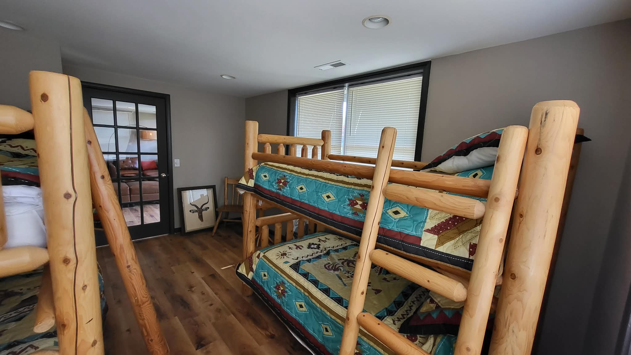 Bunk room with two sets of log bunk beds and southwestern quilts