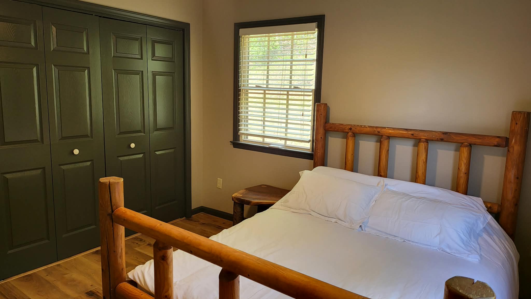 Upper level bedroom with full-size log bed frame and mountain views