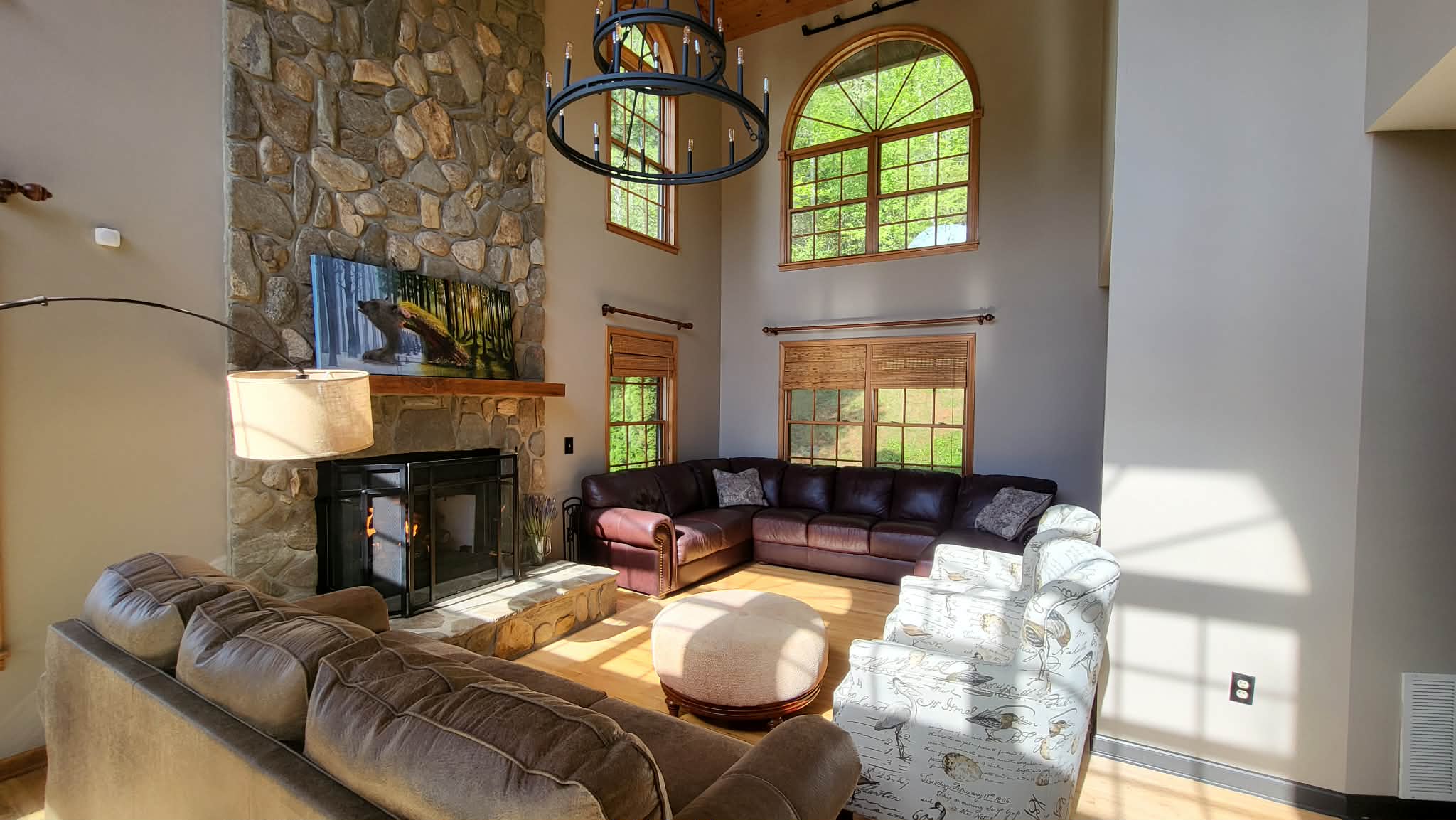 Great room with floor-to-ceiling stone fireplace, cathedral ceilings, and arched windows